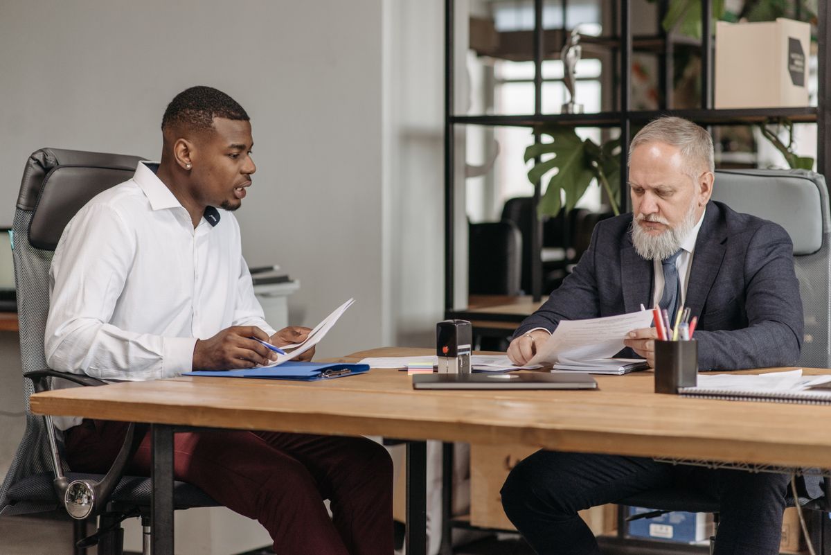 Two men reviewing documents at an office desk