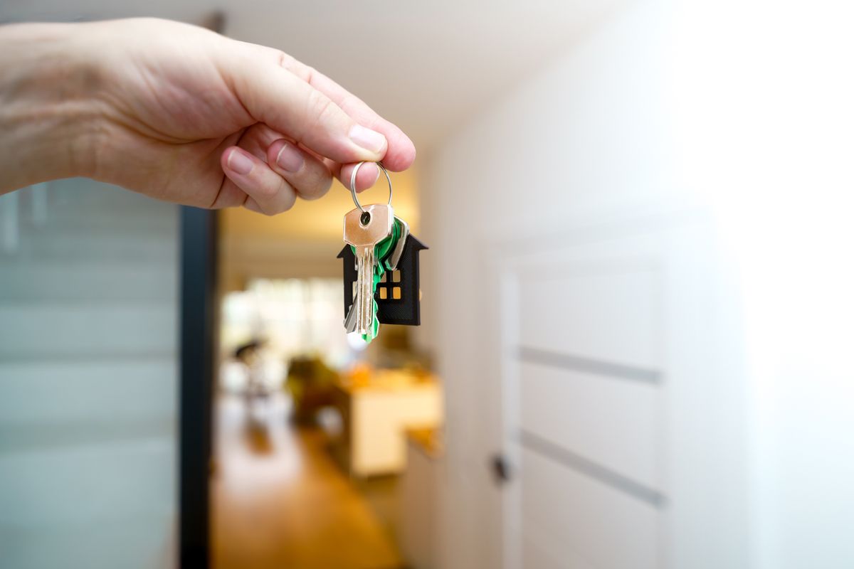 A hand holding apartment keys